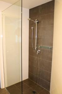 a shower with a glass door in a bathroom at Apartment On King Street in Newcastle