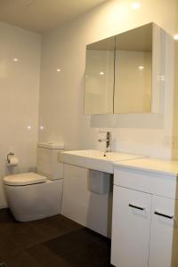 a bathroom with a toilet and a sink and a mirror at Apartment On King Street in Newcastle