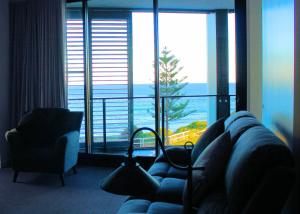 a living room with a couch and a large window at Apartment On King Street in Newcastle