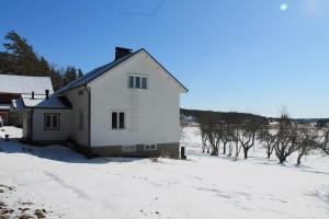 a white house in the snow with trees at Hännilän Tila in Karuna