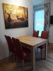 PlanneralmにあるFerienwohnung Ski-Hansのダイニングテーブル(椅子付)が備わります。壁には絵画が飾られています。