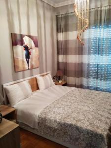 a bedroom with a bed and a large window at Maria's Apartment in Kavala