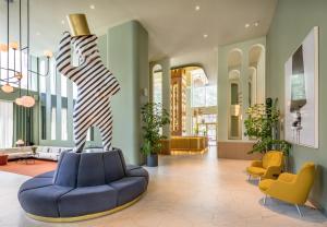 a lobby with a blue couch and a statue at Barceló Torre de Madrid in Madrid