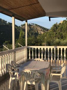 een witte tafel en stoelen op een balkon met uitzicht bij Guest House Xhuljon in Berat