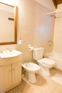 La salle de bains est pourvue de toilettes, d'un lavabo et d'une baignoire. dans l'établissement Aves del Sur, à Ushuaia