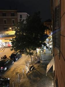 a city street at night with a tree and cars at Locanda San Cosimato in Rome