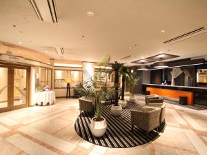 a lobby with chairs and potted plants in a building at APA Hotel Yamaguchi Hofu in Hofu