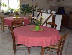 une table avec un tissu de table rose et des chaises avec des fleurs. dans l'établissement Ferme de la Lande Martel, à Juilley