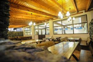 a restaurant with wooden tables and benches and windows at motel cryss in Ocna Sibiului
