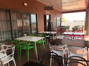 an empty restaurant with tables and chairs and windows at Northern Rock Hotel in Mpika