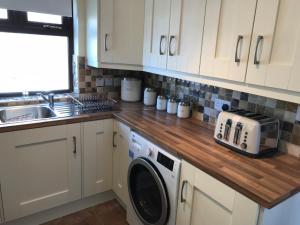 a kitchen with a washing machine and a sink at Mountain View in Newcastle