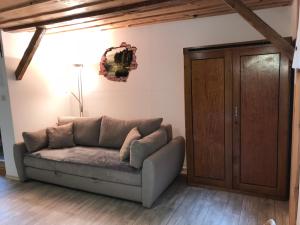 eine Couch in einem Wohnzimmer neben einer Tür in der Unterkunft Apartma & savna Slapnik in Luče