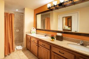 a bathroom with two sinks and a large mirror at Floridays Orlando Two & Three Bed Rooms Condo Resort in Orlando