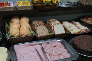 a bunch of different types of bread and pastries at Hotel Princeton in Piracicaba