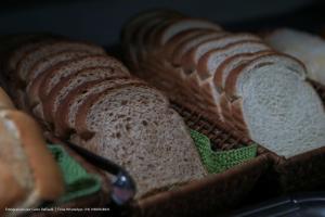 a group of breads in a basket with a spoon at Hotel Princeton in Piracicaba