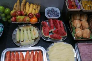 a table with trays of different types of fruits and vegetables at Hotel Princeton in Piracicaba