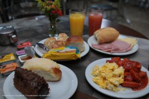 a table topped with plates of breakfast foods and drinks at Hotel Princeton in Piracicaba
