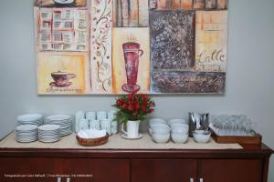a table with plates and cups and flowers on it at Hotel Princeton in Piracicaba