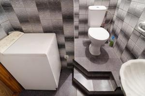 a bathroom with a white toilet and a sink at Like A Home in Sumy
