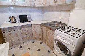 a small kitchen with a stove and a sink at Like A Home in Sumy