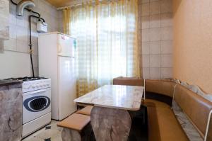 a small kitchen with a table and a refrigerator at Like A Home in Sumy