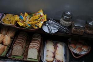 a shelf filled with different types of bread and snacks at Hotel Princeton in Piracicaba