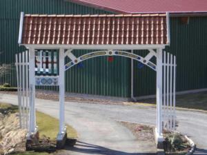 a gate with a roof on the side of a street at Ferienwohnungen von Schassen in Twielenfleth +46 photos