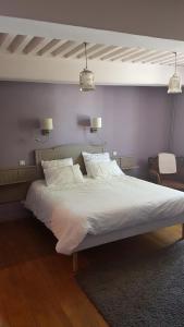 a large bed with white sheets and pillows in a bedroom at Chambres d'hôtes Du Goût et des Couleurs in Grenay