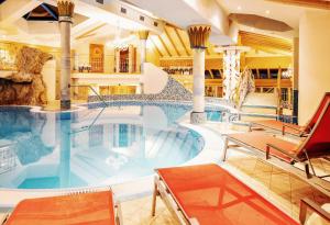 una piscina en un hotel con sillas y una piscina en Hotel Neuhintertux en Tux