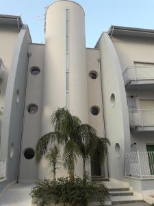 un edificio con una palma di fronte di Appartamento "Le Vele" a Castellammare del Golfo