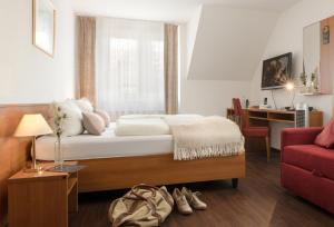 a hotel room with a bed and a television at Business Hotel Böblingen-Sindelfingen in Böblingen