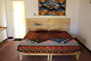 卡佩蹄尤的住宿－Margarita kitesurfing school Sri Lanka，卧室内的一张带木制床头板的床