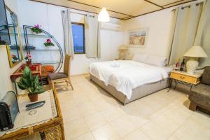ein Schlafzimmer mit einem Bett, einem Stuhl und einem TV in der Unterkunft Hapinukim Shel Rozi in Ein Tamar 