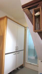 a large white cabinet in a room with a window at Camões Lofty Boho Apartment in Setúbal