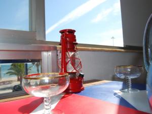 a red blender sitting on a table with two glasses at Nautic in Quarteira