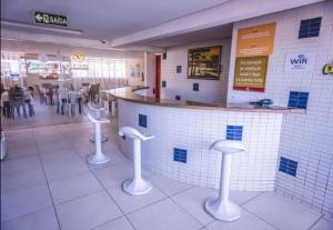 un restaurante con barra y taburetes en una habitación en Victory Business Flat, en João Pessoa