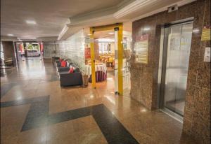 Un vestíbulo con una mesa y sillas en un edificio. en Victory Business Flat, en João Pessoa