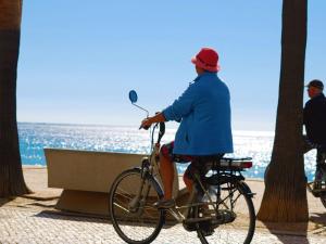 a person riding a bike near the water at Nautic in Quarteira