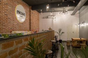 a restaurant with a counter and a brick wall at Micasa Hostels in Pondicherry