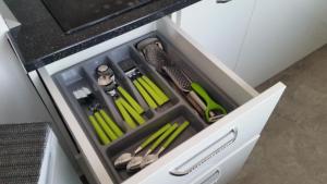 a drawer in a kitchen with green utensils at The Place in Deva