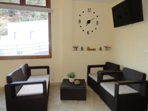 a living room with two chairs and a clock on the wall at Hotel Rural Imada in Imada