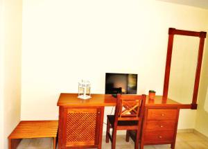 einen Holzschreibtisch mit einem Stuhl und einem TV in der Unterkunft Hotel Rural Imada in Imada