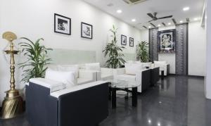 ein Wohnzimmer mit weißen Möbeln und Pflanzen in der Unterkunft Treebo Trend Omni Palace in Indore
