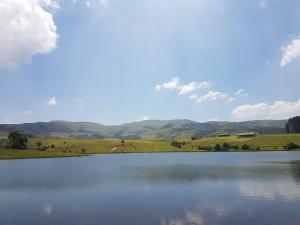 UtrechtLuiperdkloof Trout Lodge的以群山为背景的湖景