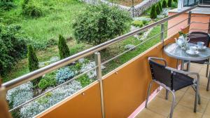 a balcony with a table and chairs and a garden at Apartmány RELAX Podhájska in Podhájska