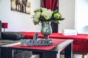 uma mesa com um vaso de flores em cima em Apartmány RELAX Podhájska em Podhájska