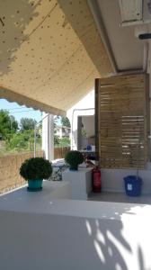 un patio con macetas y persianas de madera en The Garden en Pefki
