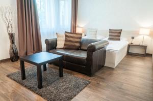 a living room with a couch and a coffee table at Hotel U Kašny in Rajhrad