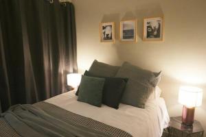 een slaapkamer met een bed met kussens en 2 lampen bij 25 on Pretorius in Potchefstroom