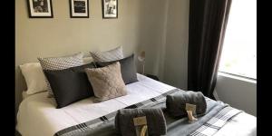 1 cama con almohadas blancas y negras y ventana en 25 on Pretorius, en Potchefstroom